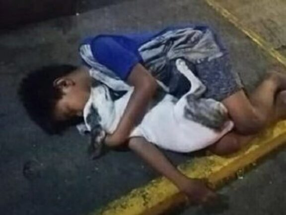 Bimbo senzatetto dorme sul marciapiede abbracciato al cane
