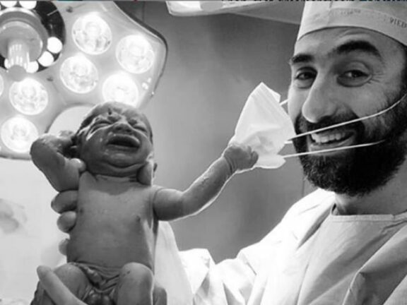 La speranza: foto di neonato che strappa la mascherina al medico